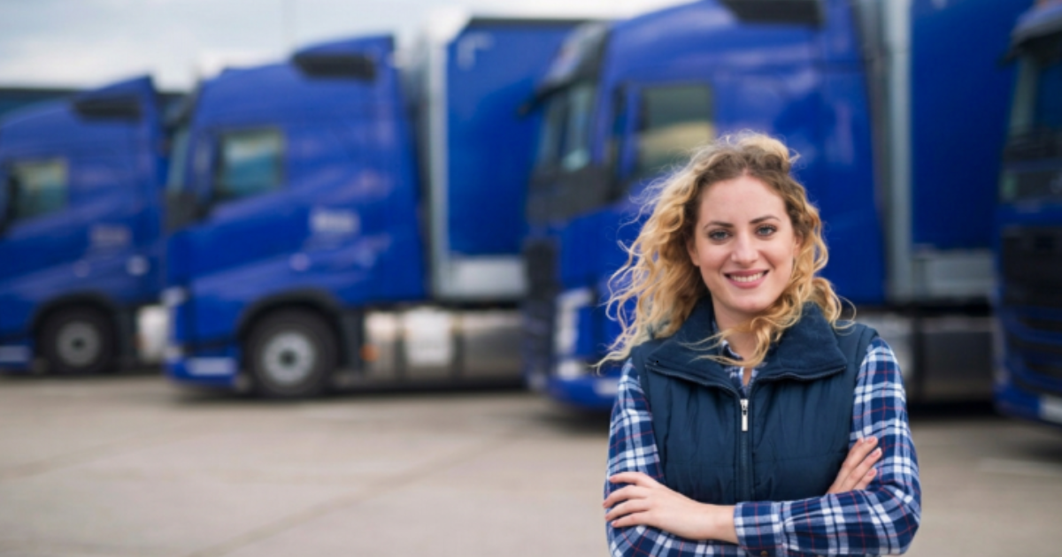 Conductrice devant une flotte de camions